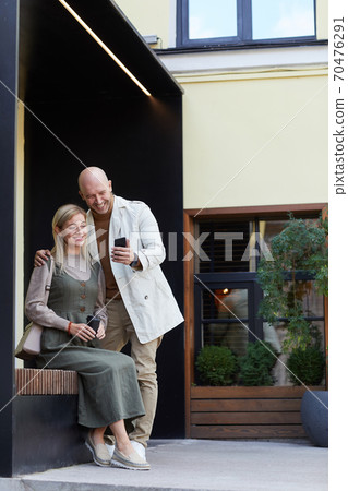 Young couple sitting outdoors Young couple sitting outdoors 70476291