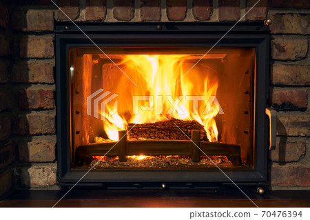fireplace and fire close view as object or background, brick wall 70476394