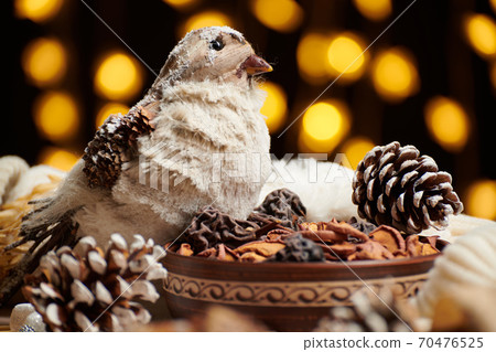 christmas decoration in rustic style and holiday lights background, still life on dark backdrop, a stuffed bird and other christmas decoration in rustic style and holiday lights background, still life on dark backdrop, a stuffed bird and other 70476525