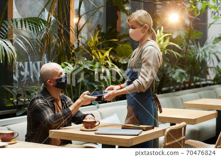 Man using phone for paying Man using phone for paying 70476824