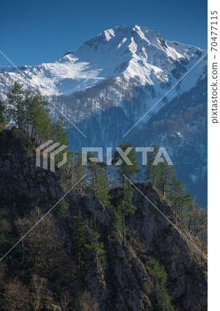Winter mountain snow peak forest view. Beautiful landscape of mountain ranges of the Caucasus Mountains in a sunny day in Krasnaya Polyana, Sochi, Russia 70477115