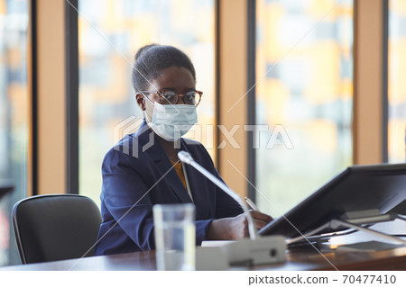 Businesswoman in mask at conference Businesswoman in mask at conference 70477410
