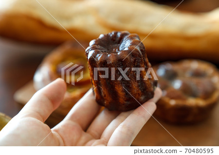 Canelé in my hand 70480595