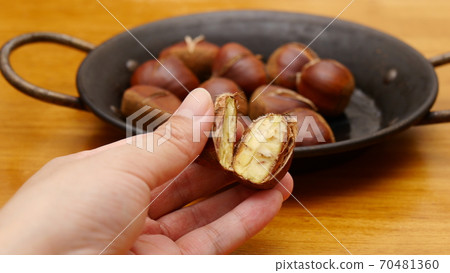 Hands with chestnuts baked in paella bread Hands with chestnuts baked in paella bread 70481360