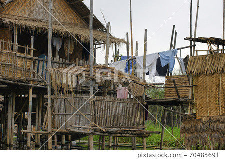 Simple bomboo house standing on piles in water in Nyaung Shwe township on Inle Lake, Burma, clothes drying on the rope Simple bomboo house standing on piles in water in Nyaung Shwe township on Inle Lake, Burma, clothes drying on the rope 70483691