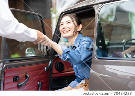 Woman getting out of the car with a man's escort Woman getting out of the car with a man's escort 70484228