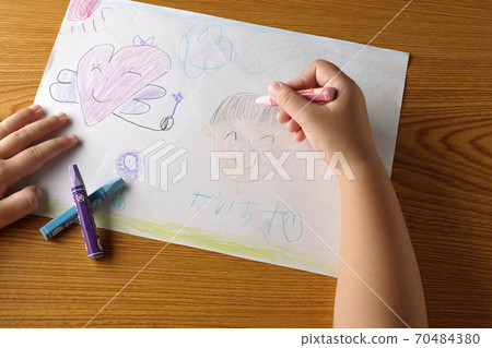 A picture drawn by a right-handed child and a cut of a part of the hand holding a crayon A picture drawn by a right-handed child and a cut of a part of the hand holding a crayon 70484380