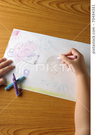 A picture drawn by a right-handed child and a cut of a part of the hand holding a crayon A picture drawn by a right-handed child and a cut of a part of the hand holding a crayon 70484381