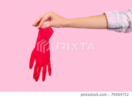 Female hand holding a pink rubber glove Female hand holding a pink rubber glove 70484752
