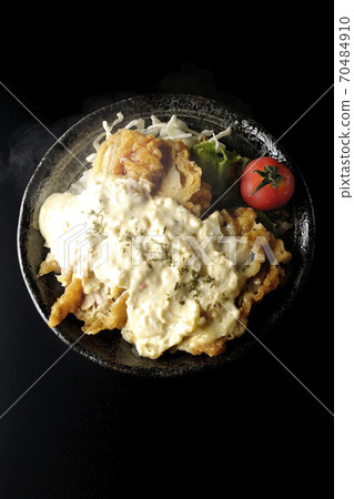 Hot chicken nanban bowl with plenty of tartar sauce with vegetables such as cherry tomatoes (black background, bird's-eye view) 70484910