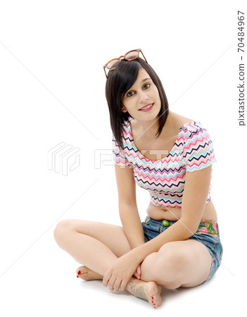 pretty young brunette woman sitting cross-legged 70484967