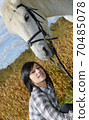 Portrait of a pretty young woman with white horse 70485078