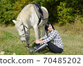 Portrait of a pretty young woman with white horse 70485202