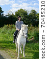young beautiful brunette woman riding horse 70485210