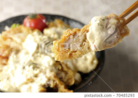 Eat a piece of chicken nanban bowl with plenty of tartar sauce with vegetables such as cherry tomatoes with chopsticks Eat a piece of chicken nanban bowl with plenty of tartar sauce with vegetables such as cherry tomatoes with chopsticks 70485293