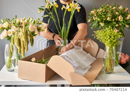 Step by step a male florist puts a set of flowers in a carton box.. Flowers bunch, set for home. Fresh cut flowers for decoration home. European floral shop. Delivery fresh cut flower. Step by step a male florist puts a set of flowers in a carton box.. Flowers bunch, set for home. Fresh cut flowers for decoration home. European floral shop. Delivery fresh cut flower. 70487214