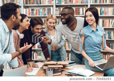 Young people at the table smiling and chatting. 70489265