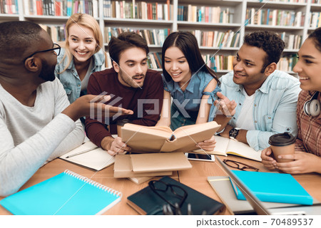Students sit together at a table and discuss. Students sit together at a table and discuss. 70489537