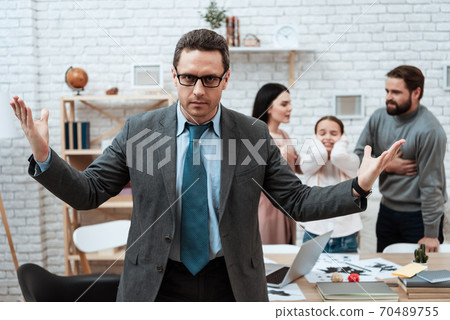 A man stands in a tie and spreads his hands. 70489755