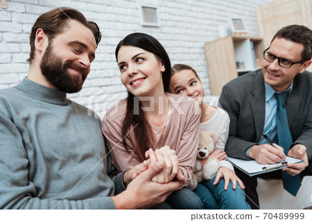 Happy family is sitting on sofa in family psychologist office. 70489999