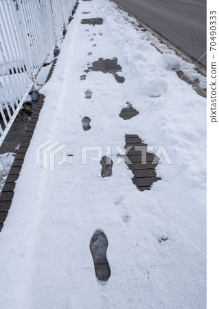 [冬季]冰雪覆蓋的人行道上的足跡垂直構圖 70490333