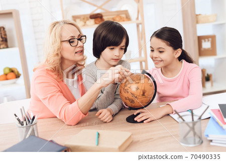 Grandmother studies geography with grandchildren. Grandmother studies geography with grandchildren. 70490335