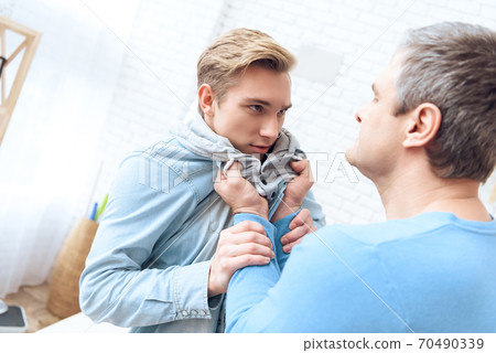 Dad took his son by the scruff and threatens him. 70490339