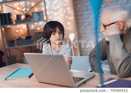 Grandfather and grandson are watching video. 70490452
