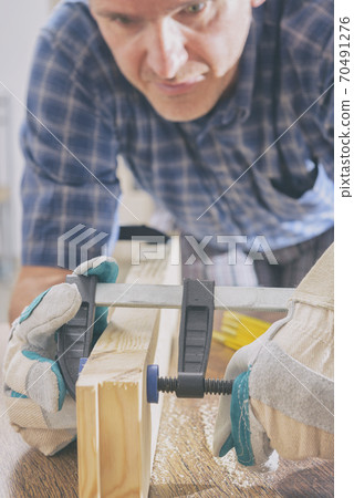Man using bar clamp in a warkshop 70491276