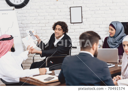 A man is showing something to an Arab colleague.  70491574