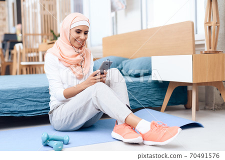 Arab woman in hijab rest after gymnastics. Arab woman in hijab rest after gymnastics. 70491576