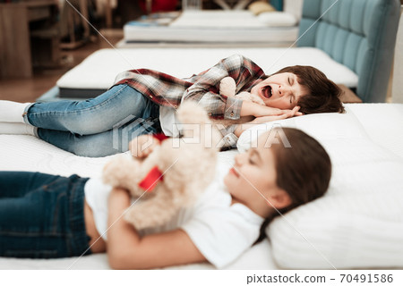 Little happy girl hugs bear lying on bed. 70491586