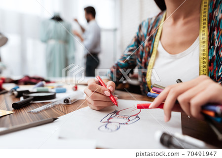 Fashion designer drawing model on paper. Fashion designer drawing model on paper. 70491947