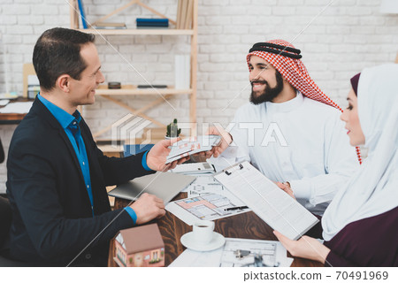 A rich male slave gives money to a realtor. A rich male slave gives money to a realtor. 70491969