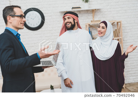 A man stands with a woman in an apartment. 70492046