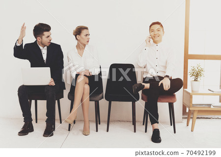 A man with a laptop sits and shouts at a man. A man with a laptop sits and shouts at a man. 70492199