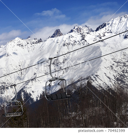 Ski resort with chair lift and snow mountains at nice sunny day Ski resort with chair lift and snow mountains at nice sunny day 70492399
