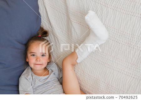 broken leg. Close-up of the cast on the feet. exercises to repair and strengthen muscles. damage to the bones. medical care of a surgeon in the emergency room 70492625