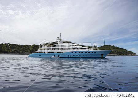 Blue luxury motor yacht, anchored in the calm sea Blue luxury motor yacht, anchored in the calm sea 70492842