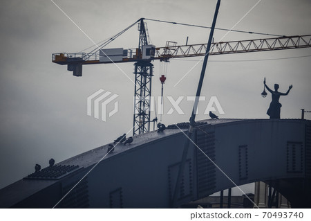 Building site crane behinf bridge with pigeons and electicity monument in Vilnius, Lithuania 70493740
