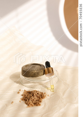 Solid bar of soap and clay powder on plate near pipette , striped shadow backround. Solid bar of soap and clay powder on plate near pipette , striped shadow backround. 70493836