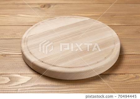 round wooden cutting board on wooden boards 70494445