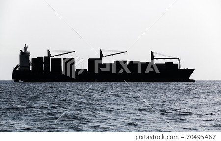 Container ship goes on sea. Blue toned silhouette 70495467