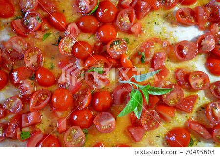 basil leaves on an uncooked pizza basil leaves on an uncooked pizza 70495603