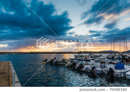 Dramatic sky over Alghero harbor at sunset Dramatic sky over Alghero harbor at sunset 70496380