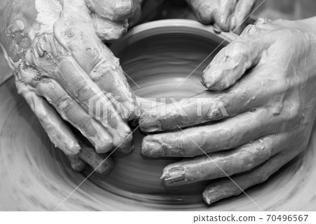 Women hands in clay at process of making crockery on pottery wheel Women hands in clay at process of making crockery on pottery wheel 70496567