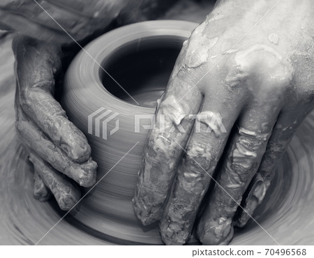 Women hands in process of making clay bowl on pottery wheel Women hands in process of making clay bowl on pottery wheel 70496568