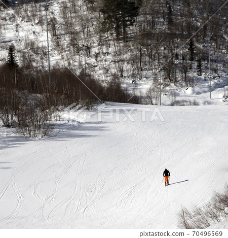 Skier on ski slope at sunny winter day Skier on ski slope at sunny winter day 70496569
