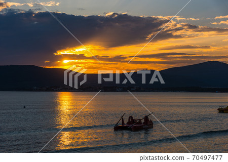 Dark clouds over Alghero shore at sunset Dark clouds over Alghero shore at sunset 70497477