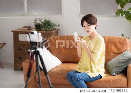 一個在鏡頭前播放推薦化妝品視頻的女人 一個在鏡頭前播放推薦化妝品視頻的女人 70499851